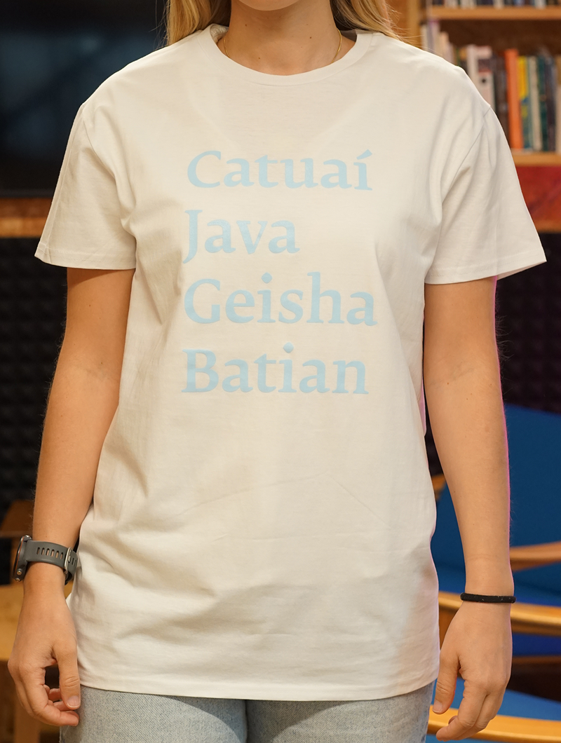 Person wearing a white t-shirt with blue text in a library setting